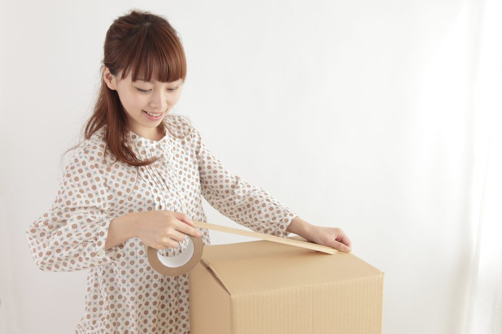 Young Asian woman in a cardboard packing